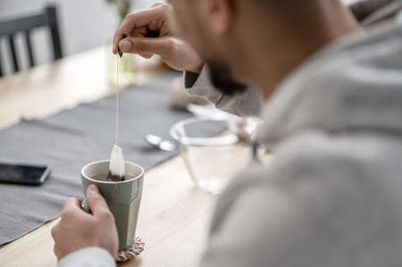 A man spending morning at home and preparing tea