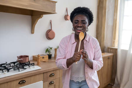 Smiling african woman singing and looking enjoyedの写真素材