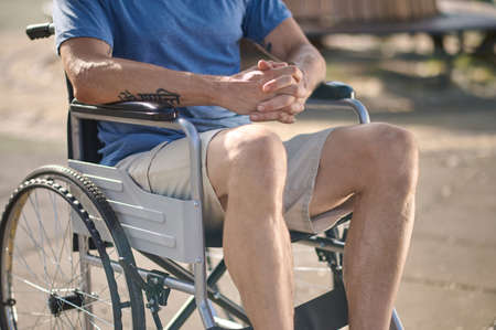 A man in shorts sitting in a wheel chai
