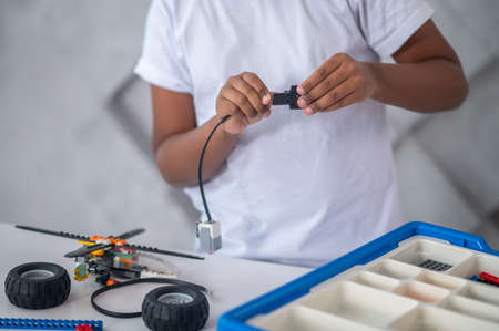 A cute teen looking busy while assembling some small piecesの写真素材