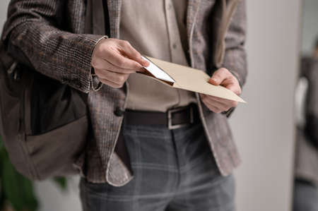 A young man in stylish jacket reading papersの写真素材