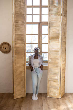 African woman in light clothes spending time at home