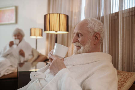 A senior couple having a peaceful morning in a hotelの写真素材