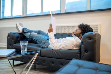 Focused businessman reading documents in his officeの写真素材