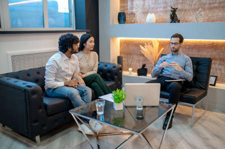 Young man and his female companion sitting in the psychologist office