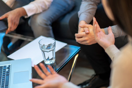 Group of three businesspeople carrying out negotiations indoors