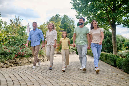 Smiling family walking hand in hand and looking happy