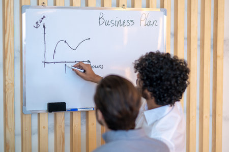 Office employee sketching a business plan for his coworker