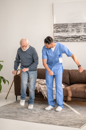Concentrated elderly patient exercising with his physiotherapistの写真素材