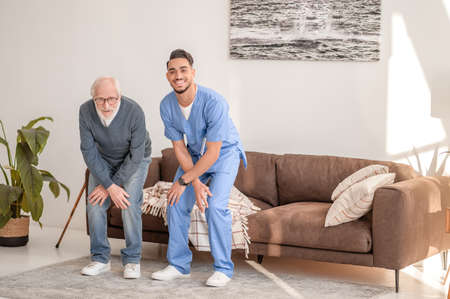 Elderly man exercising with an experienced physical therapistの写真素材