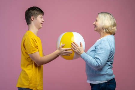 Woman and guy touching ball standing opposite each other