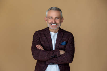 A man with a crossed arms looking contented and smilingの写真素材