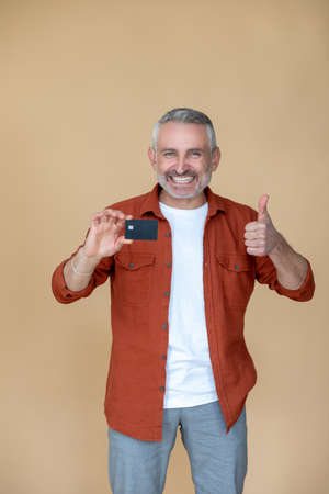 A man holding a smartphone and looking excited