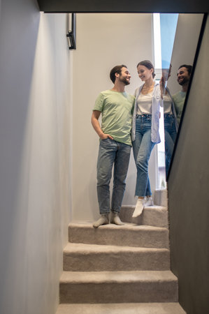 Man and woman looking at each other on stairsの写真素材