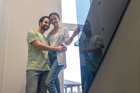 Bottom view of man hugging woman smiling at cameraの写真素材