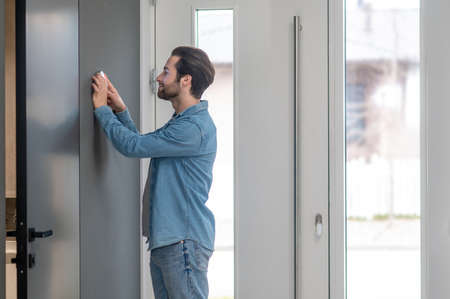 Man checking home control panel touching wallの写真素材