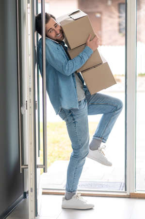 Man sideways to camera holding falling boxes