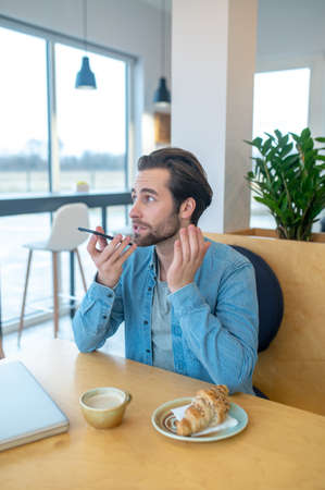 Man talking holding smartphone at mouth level