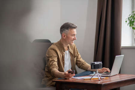 Man looking smiling at laptop screenの写真素材