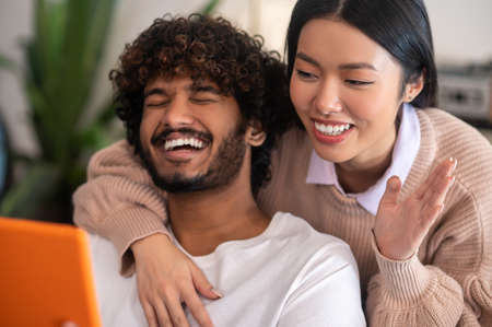 Young cute couple having a video call and looking involved