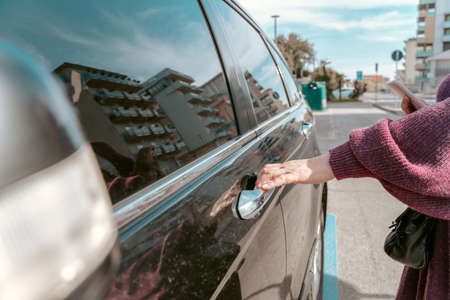 Woman touching the automotive exterior door handleの写真素材