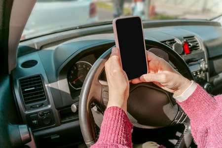 Person with the cellphone seated in the automobileの写真素材