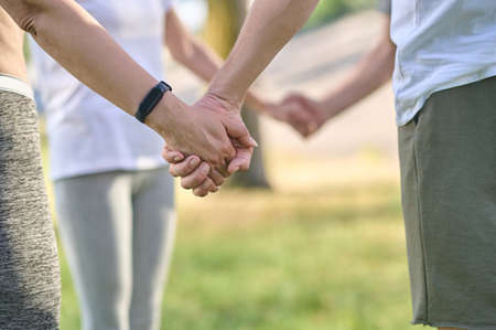 Close up picture of peples hands holding each otherの写真素材