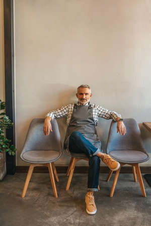 Man resting sitting on chair looking at cameraの写真素材