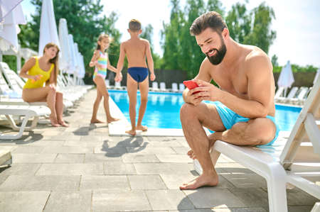 Young man resting by the swimming pool