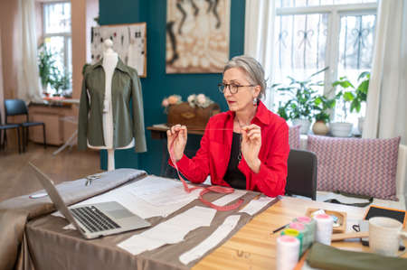 Woman with measure looking at laptop sitting at table