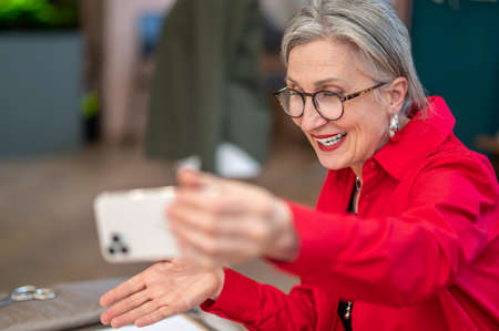 Woman talking holding smartphone in outstretched hand