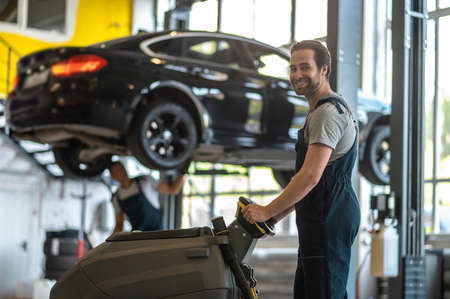 A service man working on a car in the garage