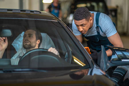 Two colleagues doing car inspection and looking involved
