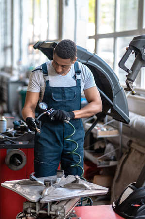 Vehicle mechanic using the equipment for measuring the tyre pressure