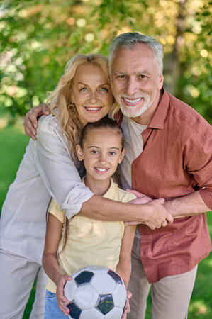 Mom, dad and daughter looking happy while spending time in the park
