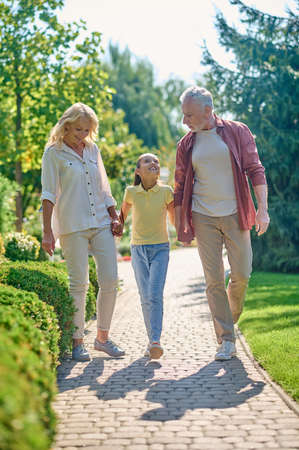 Happy family walking hand in hand in the park