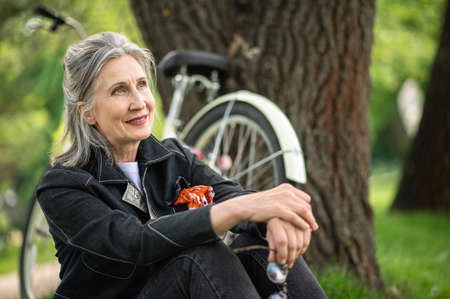 A good-looking woman in black resting near the river