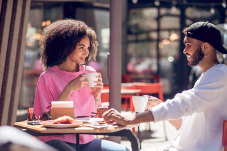 Cute young couple having coffee in the cafeの写真素材