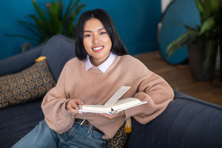 Smiling cute asian girl with a book in hands
