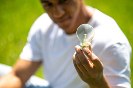 Light bulb in guys hand outdoors