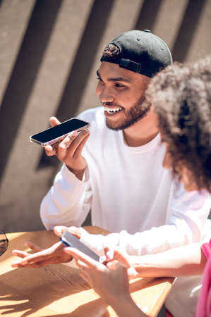 Cute smiling couple, a man recording a voice message