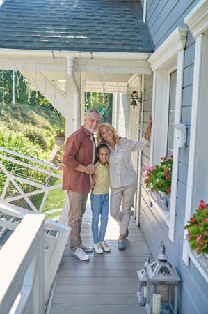 Family standing near the house and looking happyの写真素材