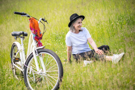 A happy woman with a black hat enjoying and having fun in the countrysideの写真素材