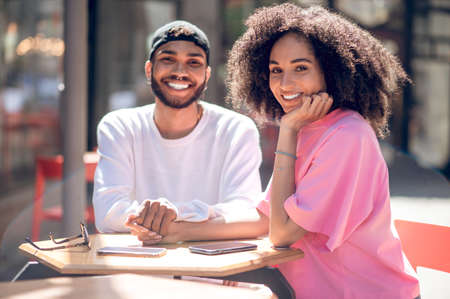 Young cute couple sitting together and watching something on internetの写真素材