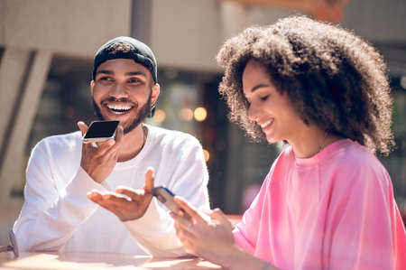 Cute smiling couple, a man recording a voice messageの写真素材