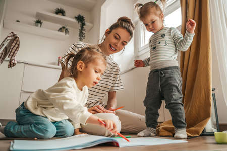 Woman and her kids involved in drawingの写真素材