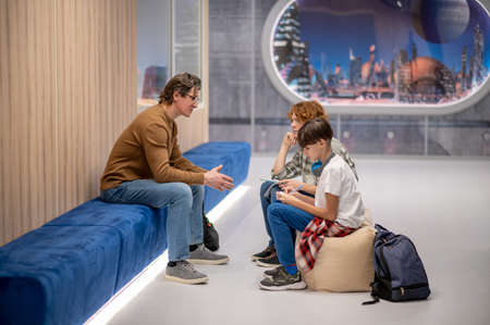 Teacher talking to his students in the school space