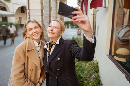 Two stylish female tourists taking a selfie
