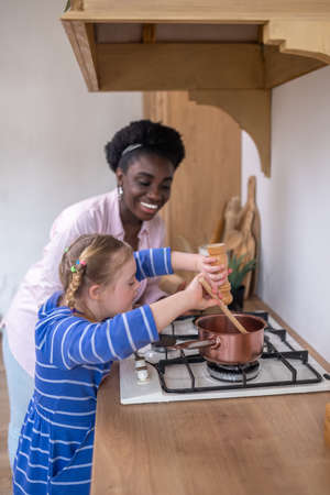 A woman and a girl looking busy while doing some houseworkの写真素材