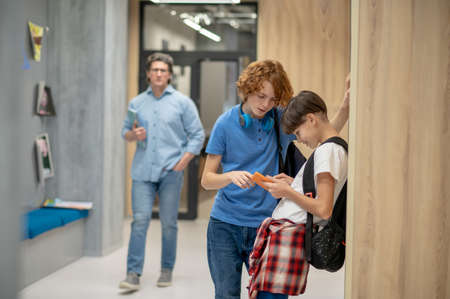 School children and a teacher in a school corridorの写真素材